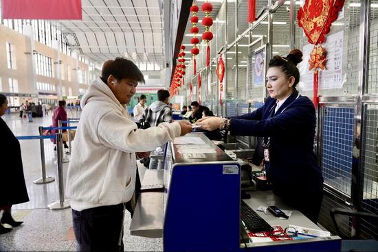 值机岗位的依帕尔古丽·阿布都沙吾提为旅客办理登机牌、行李托运手续。阿卜力克木 摄