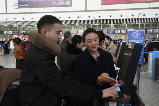 工作人员指导旅客自助打印登机牌。阿卜力克木 摄