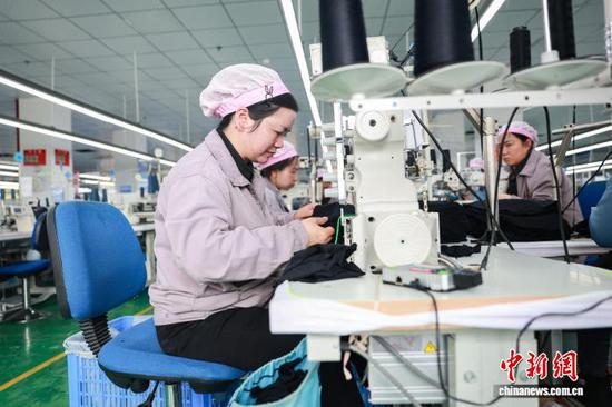 2月23日，工人在三穗县一家服饰企业的生产车间赶制服装订单产品。龙兴伟 摄