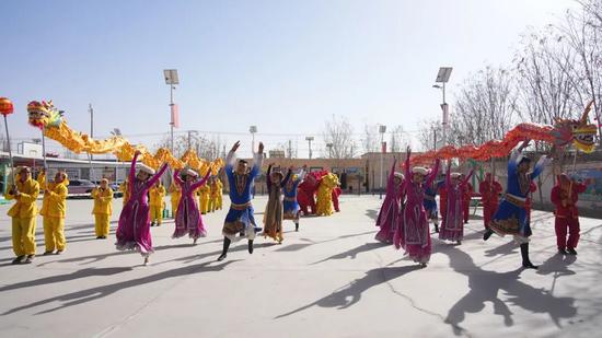 地区新玉歌舞团演员与洛浦县民间艺人联手演绎舞龙舞狮节目。