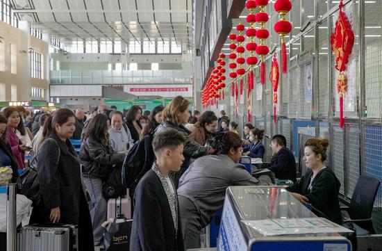 机场工作人员为旅客办理登机牌。阿卜力克木 摄