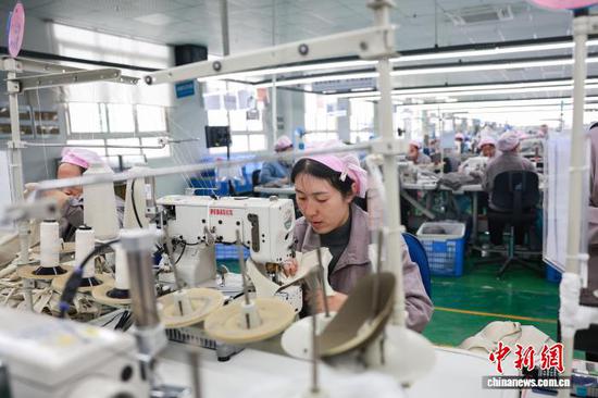 2月23日，工人在三穗县一家服饰企业的生产车间赶制服装订单产品。龙兴伟 摄