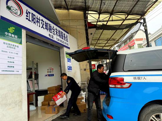 公交到达大坝镇红阳村交邮融合末端服务点  负责人在下货