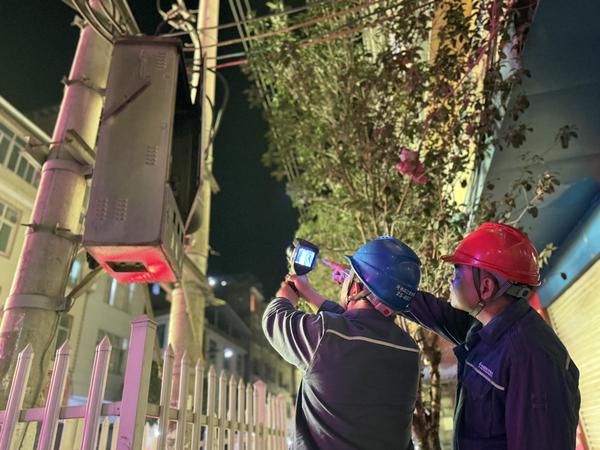 2月19日晚，环江供电局保供电人员对“返乡村”篮球比赛赛场周边供电线路和设备开展红外测温。韦家会  摄