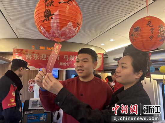 图为：旅客在列车上猜谜。中新社发 高艳 供图