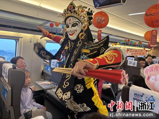 图为：列车上的变脸表演吸引旅客。中新社发 高艳 供图