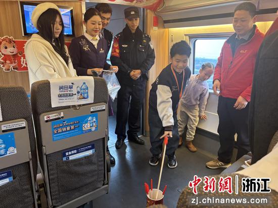 图为：旅客在高铁车厢内体验传统游戏。中新社发 高艳 供图