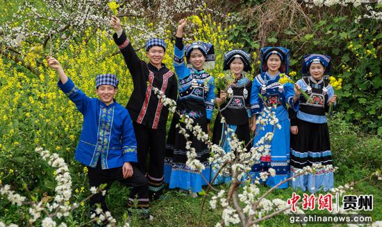 人们在罗甸县罗悃镇响水村蜂糖李种植基地赏花拍照