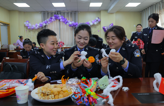 女警们在做“马上有财”手工摆件