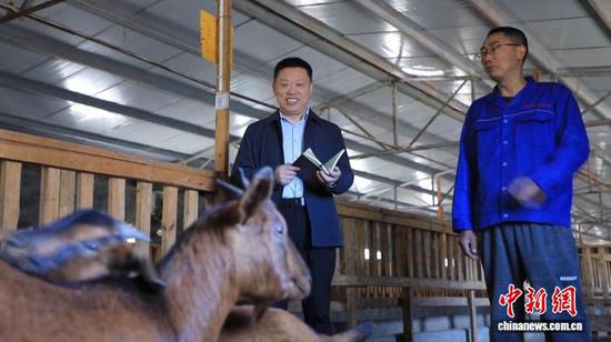 图为全国人大代表、四川省南江县五郎黄羊养殖专业合作社理事长汪其德(左)。(受访者供图)