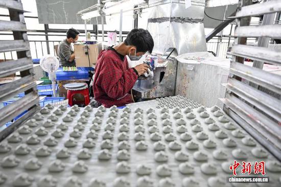 3月10日，工人在贵州省黔南州独山经济开发区的一家玩具生产企业车间加工产品。连日来，独山经济开发区内的多家玩具生产企业满负荷运转，赶制海外订单，以保障市场供应。中新社记者 瞿宏伦 摄