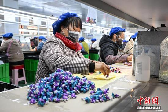 3月10日，工人在贵州省黔南州独山经济开发区的一家玩具生产企业车间加工产品。连日来，独山经济开发区内的多家玩具生产企业满负荷运转，赶制海外订单，以保障市场供应。中新社记者 瞿宏伦 摄