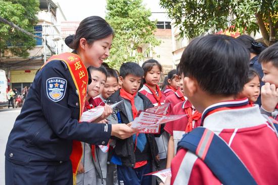 图为“多面能手”卢绪静在国门口岸给孩子们发放普法宣传资料。 向希旺 摄