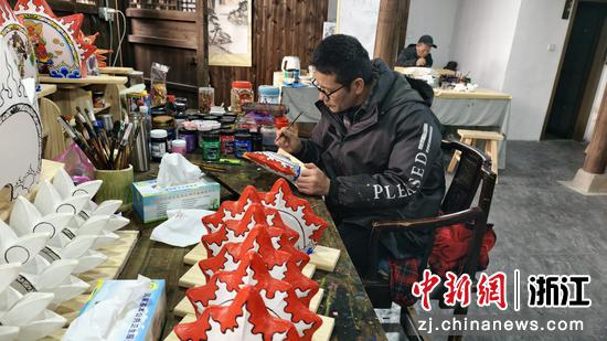 图为：工作人员为迷你板凳龙绘图上色。中新社发 郑文良 摄