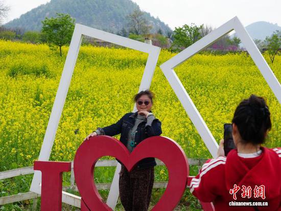 图为3月17日，游客在贵阳市南明区永乐乡的油菜花海里拍照打卡。石小杰 摄