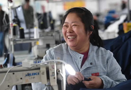 精河县维郎工业有限责任公司车间内，员工正在生产服装（资料图）。来源：博尔塔拉融媒体中心图库