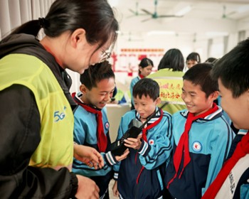 孩子们围观经典通信设备“大哥大”。陈斌 摄