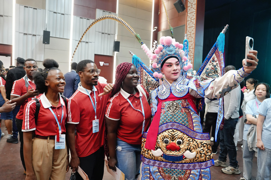 2024年5月19日至26日，第八届中非青年大联欢在北京和浙江两地举行。图为外国媒体工作人员与婺剧演员合影。