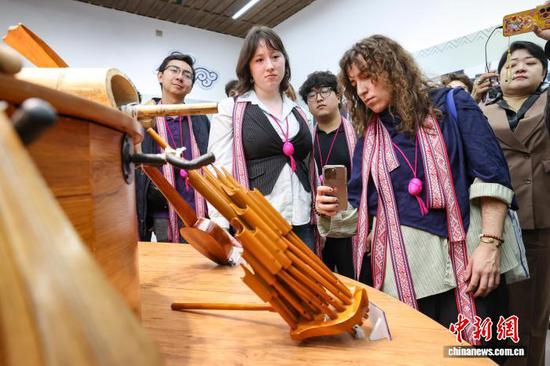 3月23日，耶鲁大学Whiffenpoofs合唱团成员在拍摄侗族乐器。中新社记者瞿宏伦摄