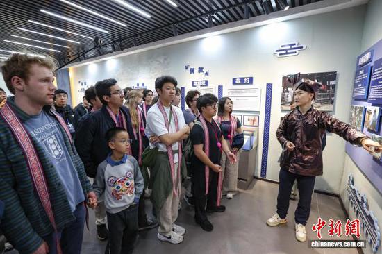 3月23日，耶鲁大学Whiffenpoofs合唱团在肇兴侗寨文化展示中心了解侗族文化。中新社记者瞿宏伦摄
