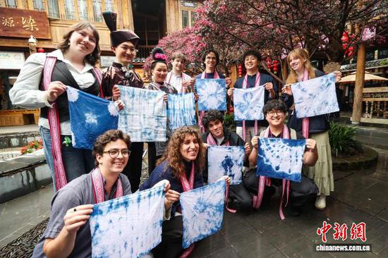 3月23日，耶鲁大学Whiffenpoofs合唱团成员在肇兴侗寨手拿扎染作品合影。中新社记者瞿宏伦摄