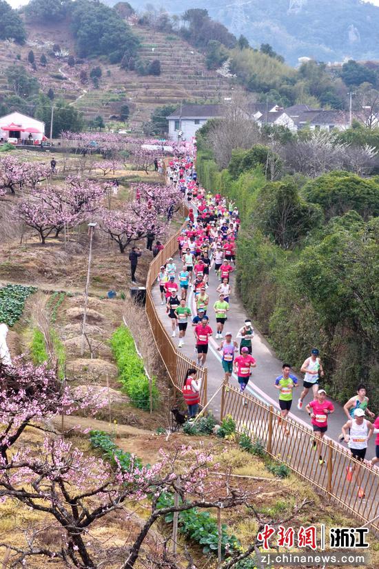 图为：众多跑者经过桃园。中新社发 樊建威 摄