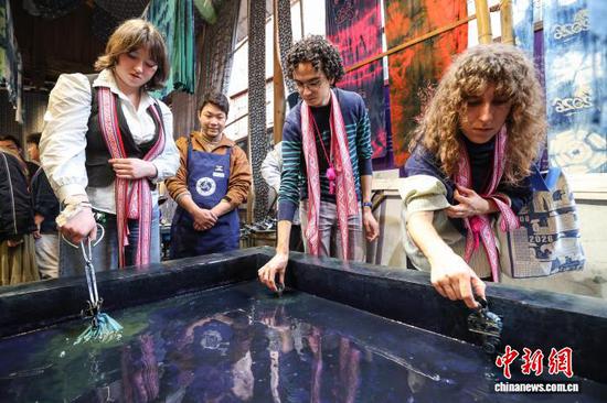 3月23日，耶鲁大学Whiffenpoofs合唱团成员在肇兴侗寨体验制作扎染。中新社记者瞿宏伦摄