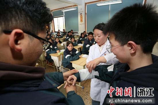 图为：护士长为学生讲解和模拟包扎方法。中新社发 单明铭 摄