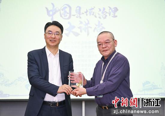 　　
图为：浙江大学公共管理学院教授王诗宗为宁波市委常委、鄞州区委书记杨勇颁发纪念品。中新社记者 王刚 摄