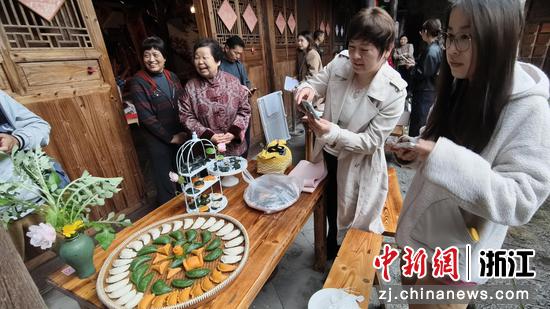 图为：清明馃制作技艺比赛吸引游人。中新社发 郑文良 摄