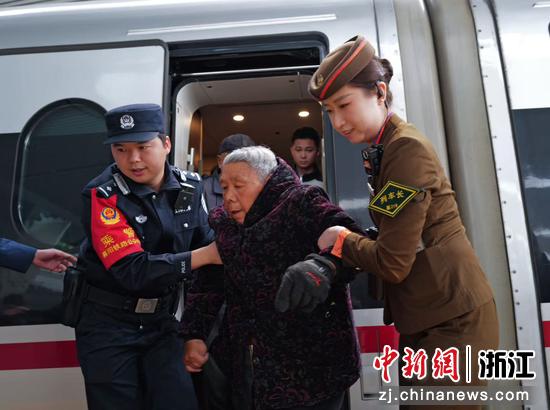 图为：民警和列车长搀扶老人。中新社发 贺瑞明 摄