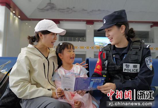 图为：民警向旅客普及反诈防骗知识。中新社发 贺瑞明 摄