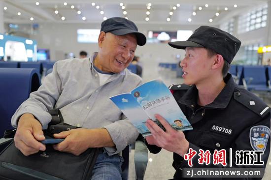 图为：民警向旅客普及反诈防骗知识。中新社发 贺瑞明 摄