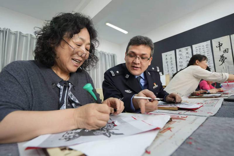 白碱滩区公安民警走进跃南社区,与各族群众共刻非遗剪纸,以文化为桥筑牢警民同心、民族团结的连心桥。(图片由市公安局白碱滩区分局提供)