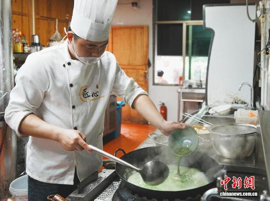 4月9日，贵州省铜仁市江口县梵净山下的一家食府内，厨师把调好的抹茶倒入锅内。中新社记者 周燕玲 摄