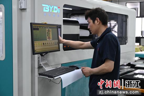 
图为技术员产线校准图案色彩，确保印花成品色泽一致。中新社发 骆泽明 摄