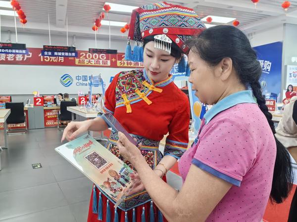 移动营业厅工作人员协助进店市民办理业务。黎曼 摄