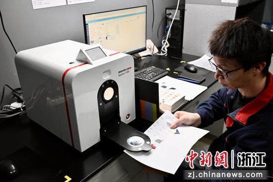 
图为技术部人员通过系统测定颜色、获取染色配方。中新社发 骆泽明 摄