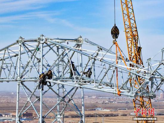 图为国网天津市电力公司工作人员在大同~天津南1000千伏特高压交流线路工程（天津段）进行吊车组塔作业。　李亚君 　摄