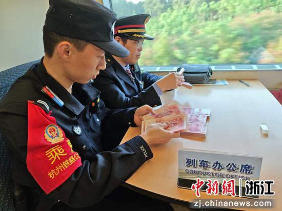 图为：乘警帮助旅客找回财物。中新社发 贺瑞明 摄