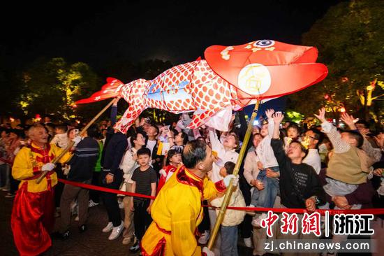 图为众多游客热情高涨，争相摸鱼头，渴望鸿运当头。