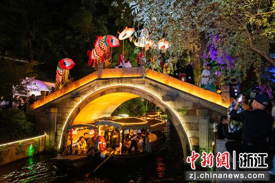 图为巡游队伍登古桥，吸引游客围观。沈勇强 摄
