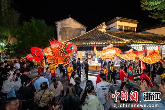 图为众多游客沉浸其间，在互动中感受民俗魅力。沈勇强 摄
