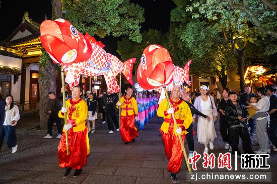 图为众多游客沉浸其间，在互动中感受民俗魅力。沈勇强 摄