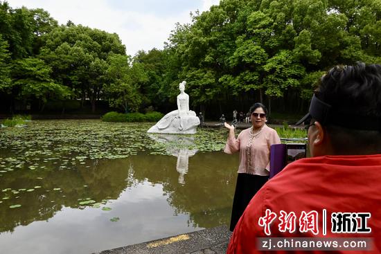 图为游客在西施雕像前打卡拍照。中新社发 骆泽明 摄