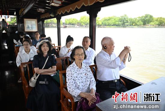 
图为：相关领导与探访团、青年宣讲团乘船前往湖心岛。中新社记者 王刚 摄