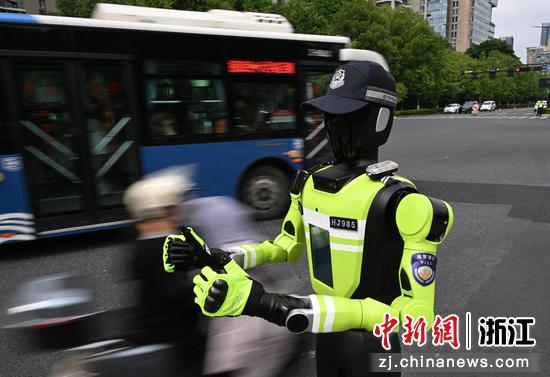 
图为：“985”号AI交管机器人在马路边为考生点赞并送上祝福语。中新社记者 王刚 摄
