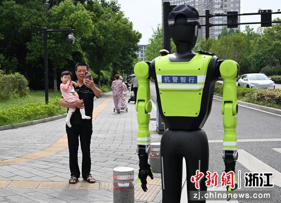 
图为：“985”号AI交管机器人吸引市民关注。中新社记者 王刚 摄