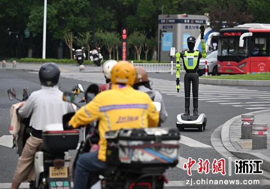 图为：“985”号AI交管机器人在路口维护交通秩序。中新社记者 王刚 摄