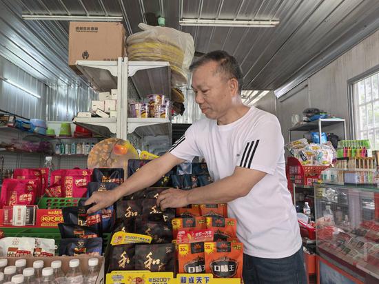 图为黄达松在整理商品。陆善迪 摄